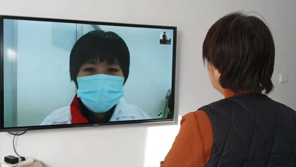 허난(河南)성 신샹(新鄕)시 훙치(紅旗)구의 한 가정집에서 주인 아주머니(오른쪽)가 TV를 통해 진료를 받고 있다.